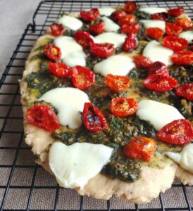 Close-up of Flatbread with cherry tomatoes, basil pesto, and mozzarella