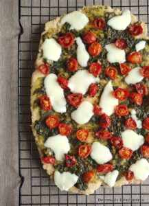 Flatbread with cherry tomatoes, basil pesto, and mozzarella