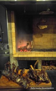 Meats cooking on open fire at Pasture Auckland